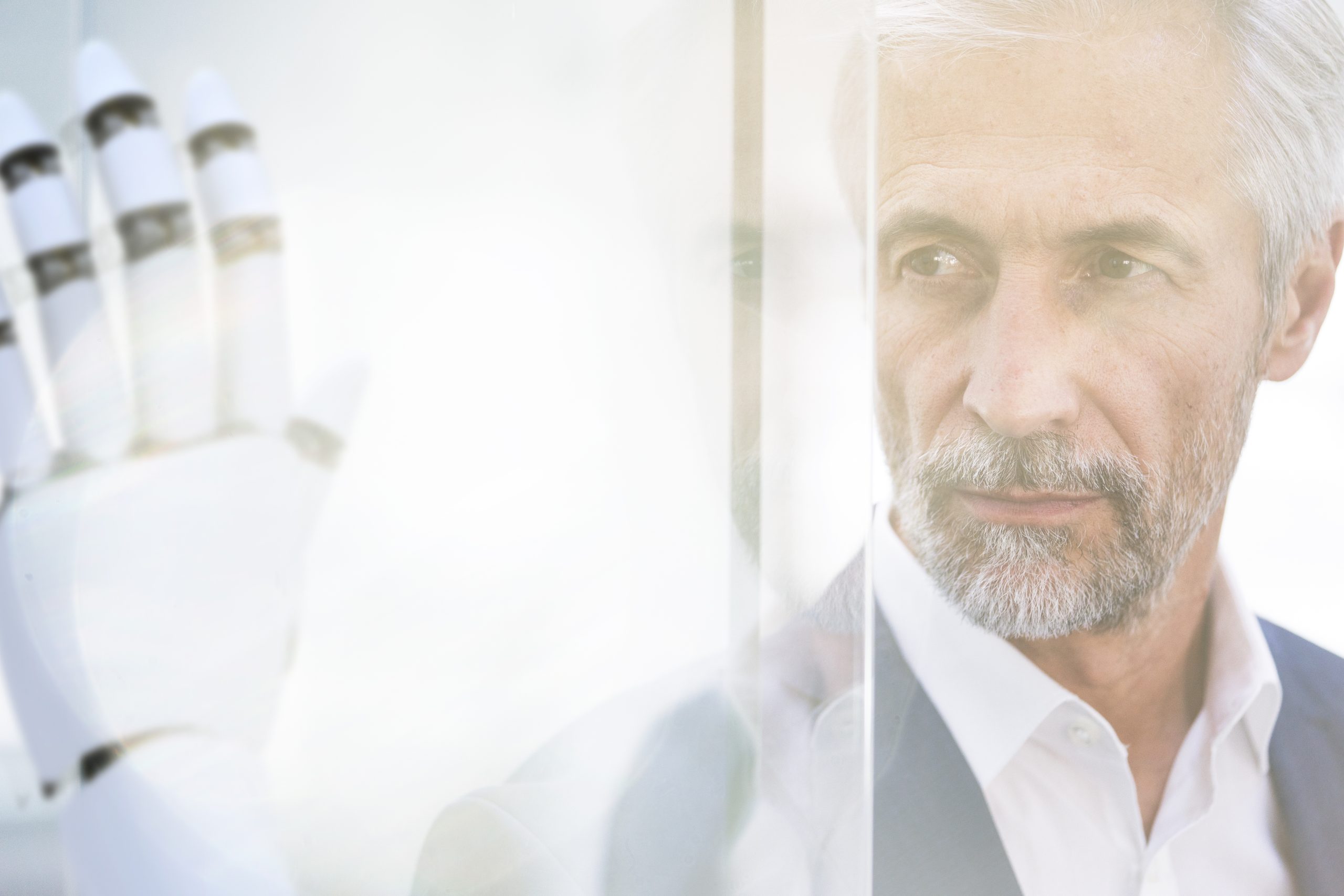 Geschäftsmann betrachtet Roboterhand